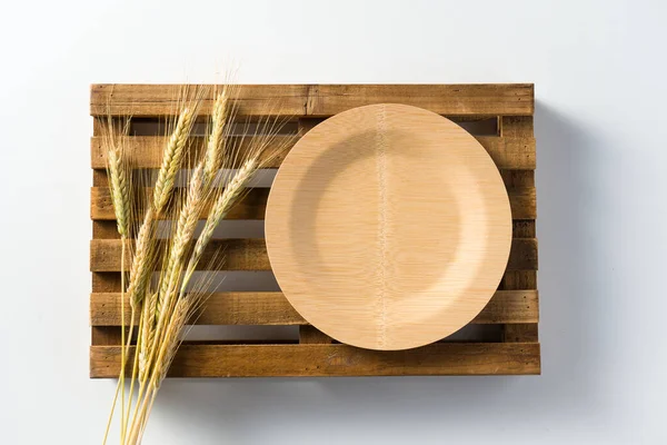 麦の耳を閉じて木製のトレイに竹のプレート 白地だ シリアルで食べるというコンセプト — ストック写真