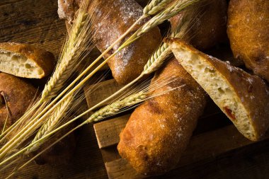 Kiraz domatesli ev yapımı ekmek. Tahta masanın üzerinde buğday kulaklı ekmek