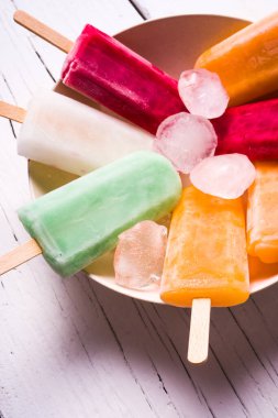 Meyveli dondurma ve buzlu kase, beyaz ahşap tahtaların üzerinde. detay