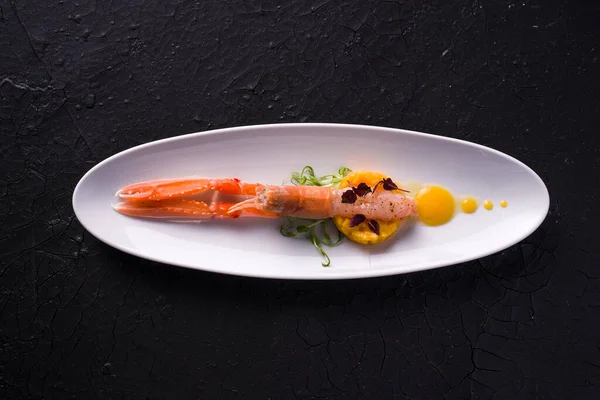 dish with marinated scampi and mango mousse. dark background top view