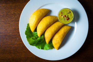 Tahta masanın üzerinde Empanadas tabağı