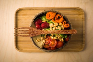 Bir kase meyve ve sebze, acai tabanı, ahududu, fıstık, domates, fıstık ezmesi. Kahvaltı tepsisi. tepeden görünüm