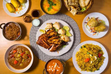 Hint mutfağının tipik yemekleri: Alu Bonda, Chicken Biryani, Chicken Curry, Chicken Makhanni, Chicken Tandoori, Dal Tarka, korma, Rogan Josh, Samosa, Naan. tepeden görünüm