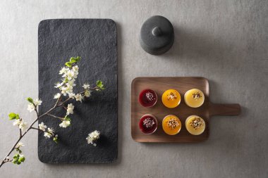 Gri yüzey ve erik dalı üzerinde, meyve ve ricotta jöleli kek grubu bileşimi.