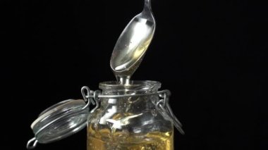 Cam bir kavanoza damlayan agave şurubuyla kaşık. Doğal agave nektarı