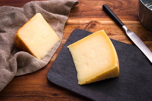 Tahta masanın üzerinde sardalya pekorino peyniri parçaları.