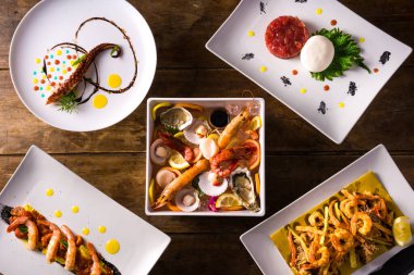 Restoran yemekleri, çiğ balık, mozzarella ile et, karışık kızarmış, ahtapot ve karidesli tortelli. Yukarıdan bak. tahta arkaplan