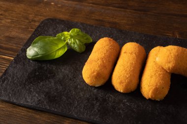 Patates kroketli tepsi ve fesleğen yaprağı