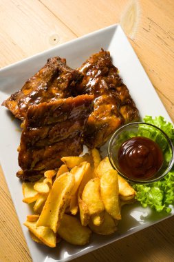 BBQ soslu domuz pirzolası ve ahşap masanın üzerine patates ezmesi. detay