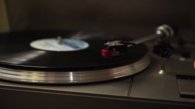 Pikabın kolu vinil plağın üzerine iniyor. Müzik eski pikapta başlar.