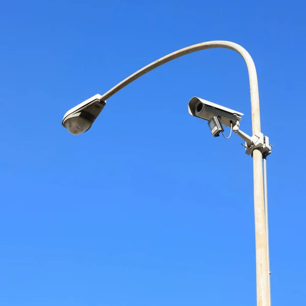 security camera on the street lamp. blue sky as a background