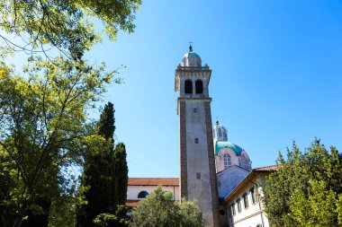 Çan kulesinin manzarası ve Barbana adasındaki tapınağın kubbesi. Friuli Grado.