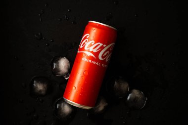 Udine, Italy - August 21, 2022. Coca Cola can top view on dark background with ice cubes