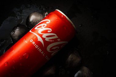 Udine, Italy - August 21, 2022. Detail of a can of Coca Cola on a dark background with ice cubes