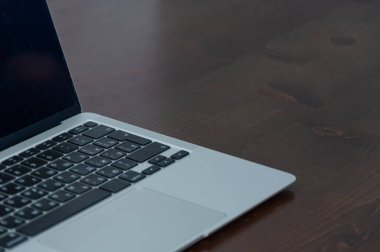 kahverengi masadaki dizüstü bilgisayar klavyeyi kapatır