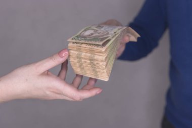  Erkek, bir kadının ellerine 500 Hryvnia 'lık bir yığın para verir.