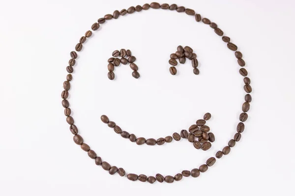 Emoticono alegre hecho de granos de café sobre un fondo blanco — Foto de Stock