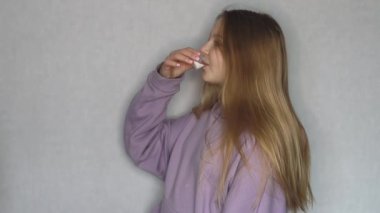 Avrupa görünümlü kız hafif bir arka planda ilaç içiyor 