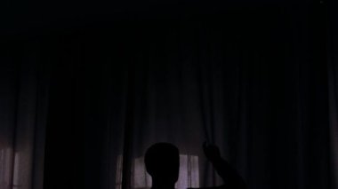 Adam sabah yatak odasında mor perdeleri aç, ağır çekimde.