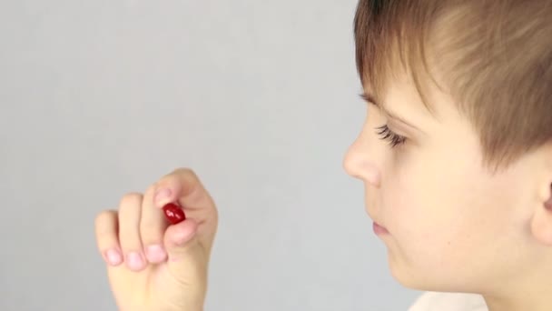 Chlapec evropského vzhledu zkoumá kapsli vitamínů — Stock video