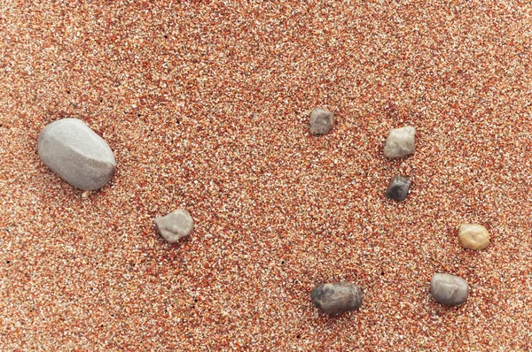 Pláž se žlutým pískem zblízka, krásné kameny v rámu — Stock fotografie