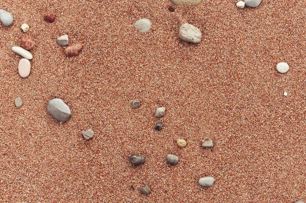 Pláž se žlutým pískem zblízka, krásné kameny v rámu — Stock fotografie