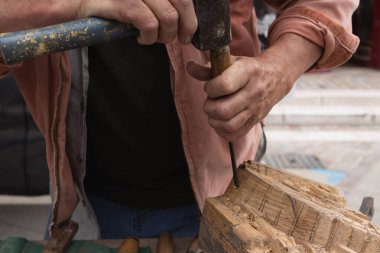 Bir adam ağaçtan kendi elleriyle ve yakın plan bir aletle ağaç üretir. Yüksek kalite fotoğraf
