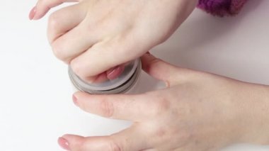 a girl opens a face mask, close-up on her hands isolated on a white background, close-up, slow motion. High quality FullHD footage
