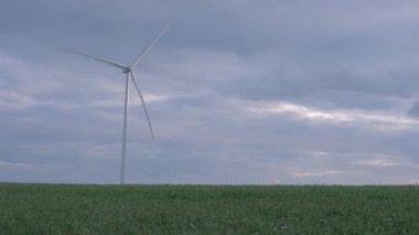 Yeşil bir alanda yel değirmeni, güzel bir arazide izole edilmiş, elektrik üreten, sağda yazıtlar için bir yer var. Yüksek kalite 4k görüntü