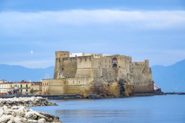 Turkuaz körfez, kumlu sahil, yeşil dağlar ve bitkiler, mavi gökyüzü, beyaz bulutlar arka plan, Capo Vaticano kaya platformu, Calabria, güney İtalya.