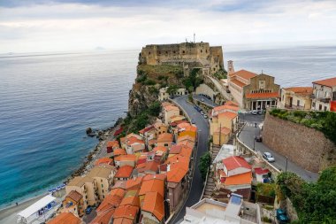 Turkuaz körfez, kumlu sahil, yeşil dağlar ve bitkiler, mavi gökyüzü, beyaz bulutlar arka plan, Capo Vaticano kaya platformu, Calabria, güney İtalya.