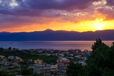 Turkuaz körfez, kumlu sahil, yeşil dağlar ve bitkiler, mavi gökyüzü, beyaz bulutlar arka plan, Capo Vaticano kaya platformu, Calabria, güney İtalya.