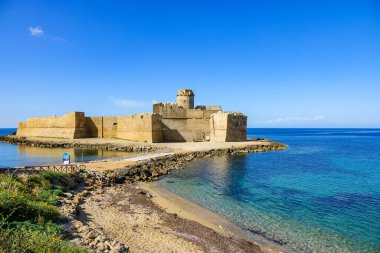 Turkuaz körfez, kumlu sahil, yeşil dağlar ve bitkiler, mavi gökyüzü, beyaz bulutlar arka plan, Capo Vaticano kaya platformu, Calabria, güney İtalya.