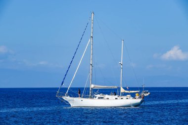 Turkuaz körfez, kumlu sahil, yeşil dağlar ve bitkiler, mavi gökyüzü, beyaz bulutlar arka plan, Capo Vaticano kaya platformu, Calabria, güney İtalya.