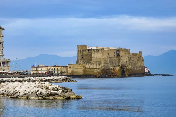 Turkuaz körfez, kumlu sahil, yeşil dağlar ve bitkiler, mavi gökyüzü, beyaz bulutlar arka plan, Capo Vaticano kaya platformu, Calabria, güney İtalya.