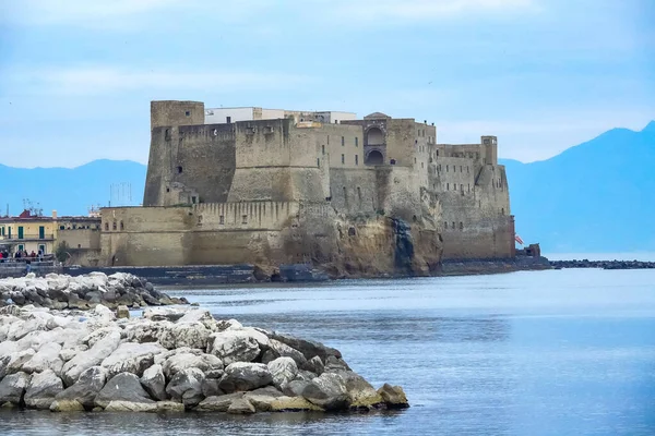 Turkuaz körfez, kumlu sahil, yeşil dağlar ve bitkiler, mavi gökyüzü, beyaz bulutlar arka plan, Capo Vaticano kaya platformu, Calabria, güney İtalya.