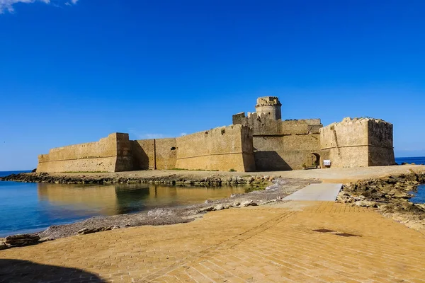 Turkuaz körfez, kumlu sahil, yeşil dağlar ve bitkiler, mavi gökyüzü, beyaz bulutlar arka plan, Capo Vaticano kaya platformu, Calabria, güney İtalya.
