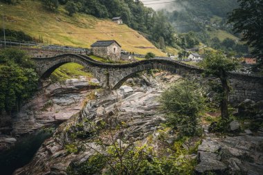 View of Lavertezzo village, famous tourist destination - An old Swiss village with double arch bridge on Ponte dei Salti with waterfall, Lavertezzo, Verzasca Valley