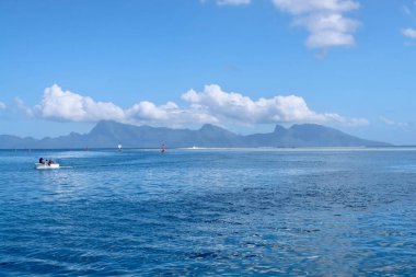 Geniş bir denizi ve arka planda beyaz bulutları olan güzel bir sahil manzarası..