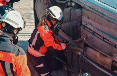 İtfaiyeci kadın kaza sırasında kaza yapmış bir arabayı kontrol ediyor.