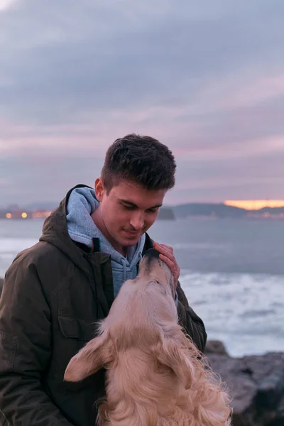 Yeni yetme köpeğine sevgiyle bakıyor.