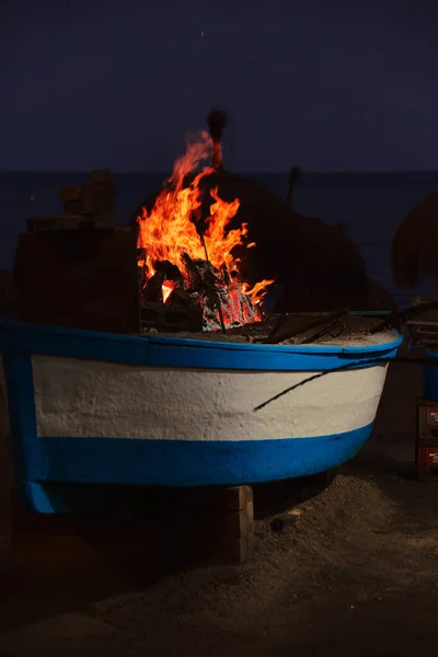Malaga sahilinde bir teknede barbekü. Geceleri sardalya broşürü pişirmek için.