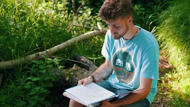 Étudiant Examinant Les Notes Dans Son Carnet Dans Parc Milieu — Video