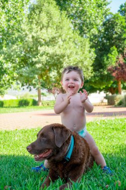 small child playing with a dog in the garden