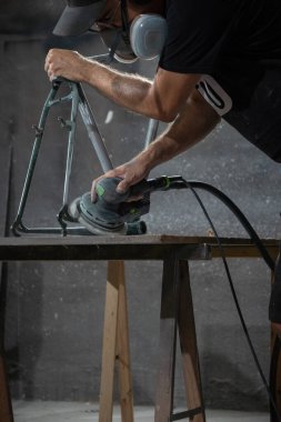 man working on a steel bicycle frame