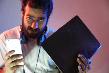 Bilgisayar ve cep telefonu olan bir bilgisayar korsanı.