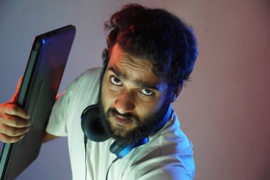 Dizüstü bilgisayarı olan ve sinirli genç bir adam.