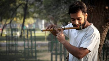 Bansuri oyuncusu Park 'ta gün ışığında müzik çalıyor - Hint Flüt Oynatıcı