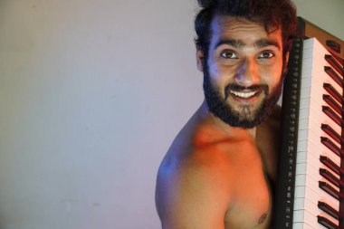 Elektronik piyanolu mutlu yüz adam.