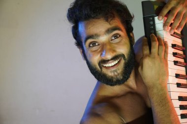 Elektronik piyanolu mutlu yüz adam.